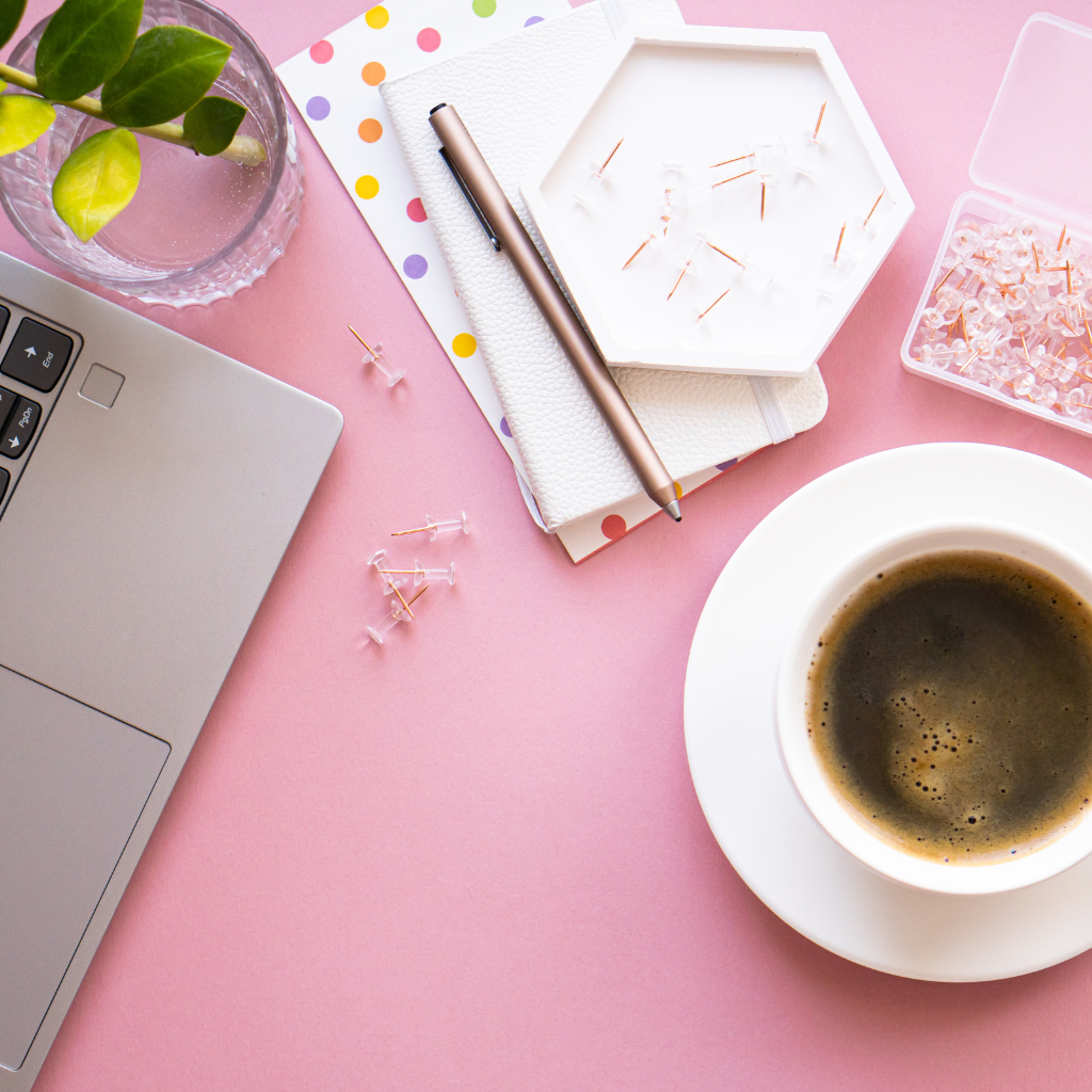pink desk and laptop with coffee